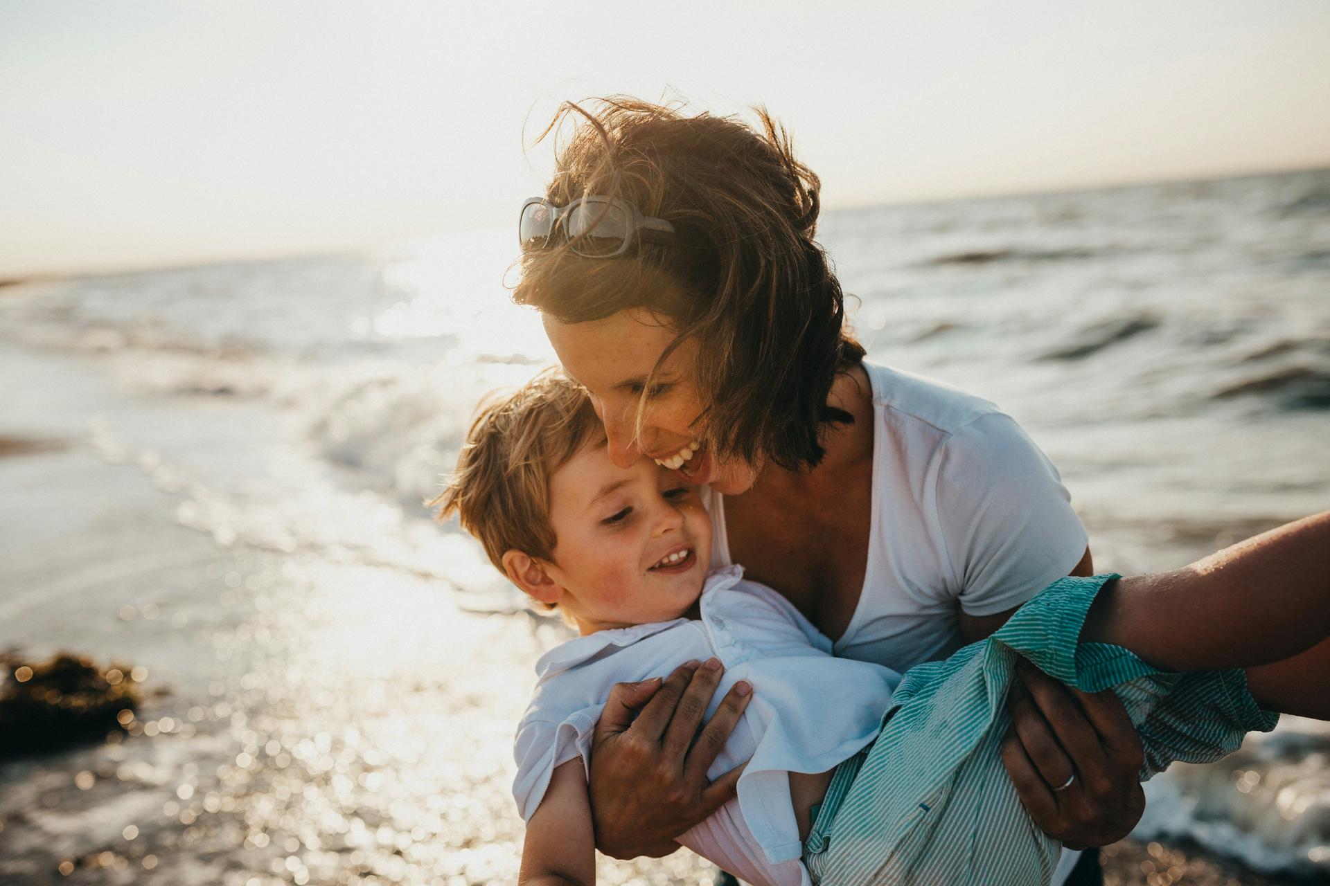 Mãe abraçando filho na praia — vacinação humanizada Primme